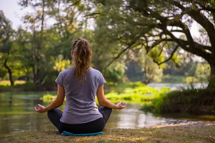 Adolescentes meditando en un lago